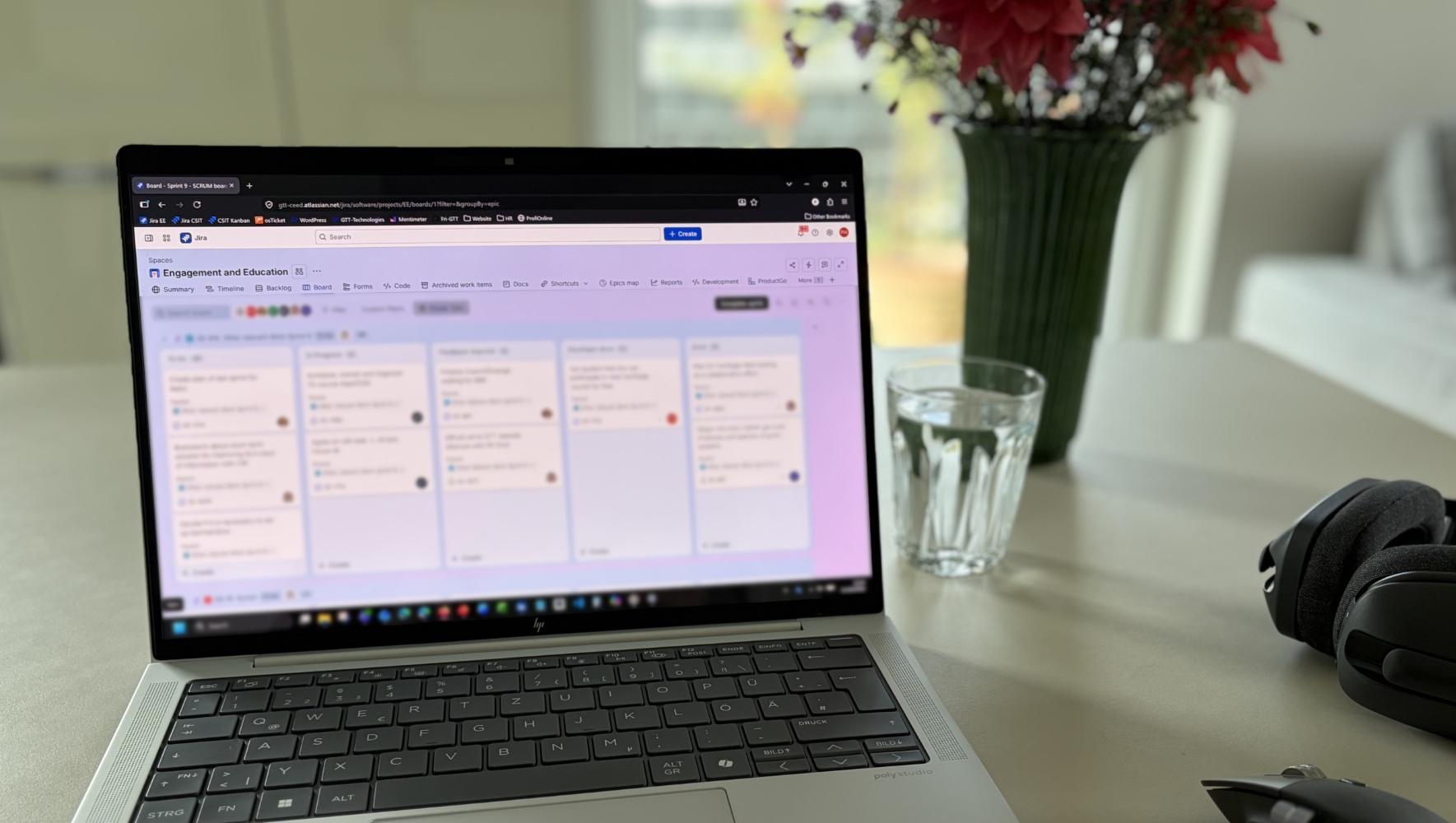 Laptop displaying a blurred Jira board on a desk in a GTT-Technologies workspace.